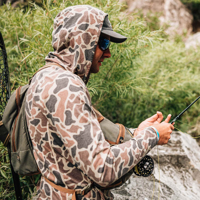 man holding fishing rod wearing camo hoodie