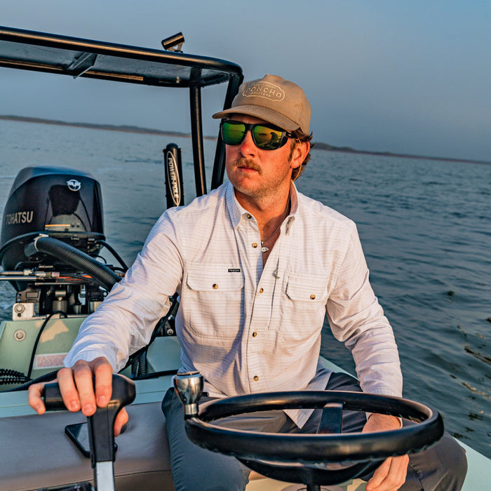 man driving boat wearing the skiff shirt