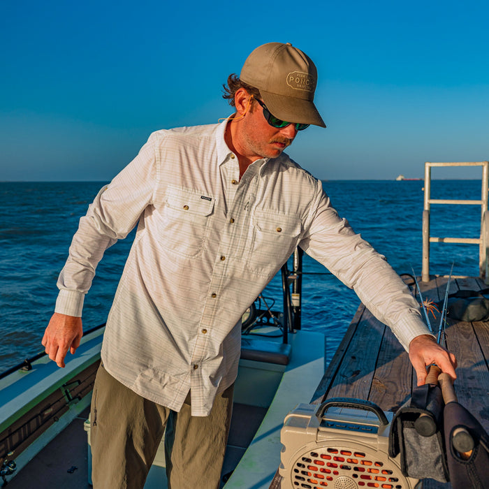 man grabbing fishing rods wearing the skiff shirt
