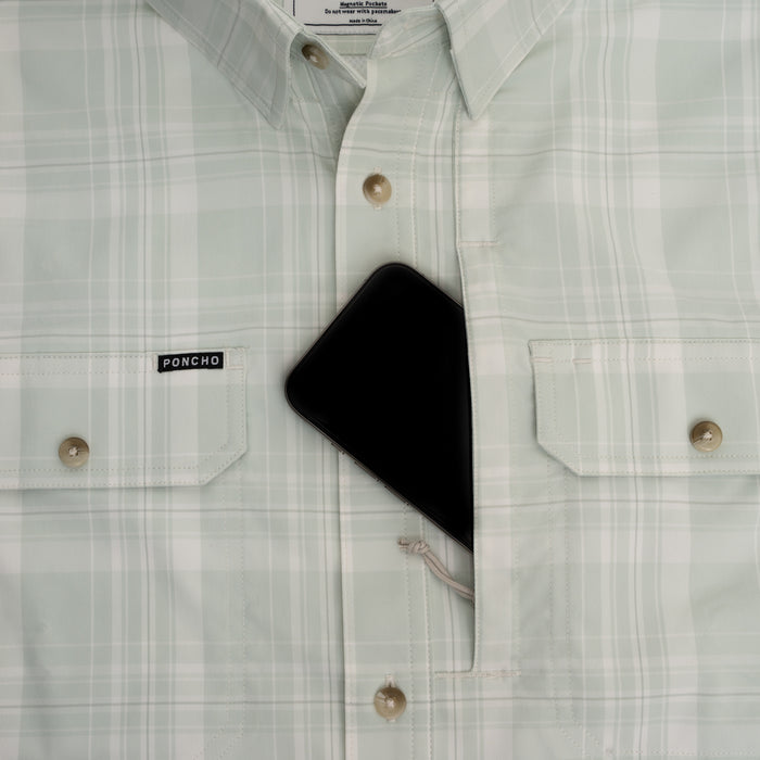 Phone in chest pocket of green plaid button down shirt