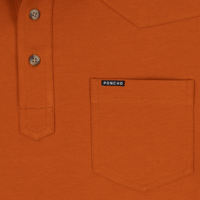 Close-up of the orange shirt pocket with buttons and a small Poncho label from The Speedway collection.