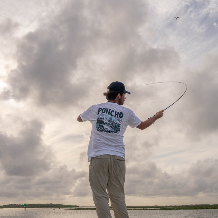 Man casting a fly rod while wearing The Sport Fisher T-shirt