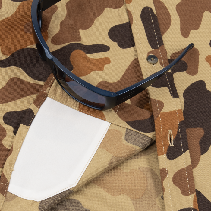Close-up of The Stuttgart shirt with brown and tan camouflage pattern and black sunglasses resting on the white chest pocket.