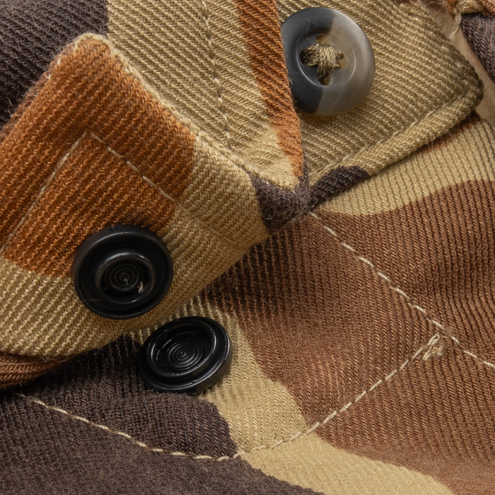 Close-up of The Stuttgart shirt fabric with brown and tan camouflage pattern and black buttons.