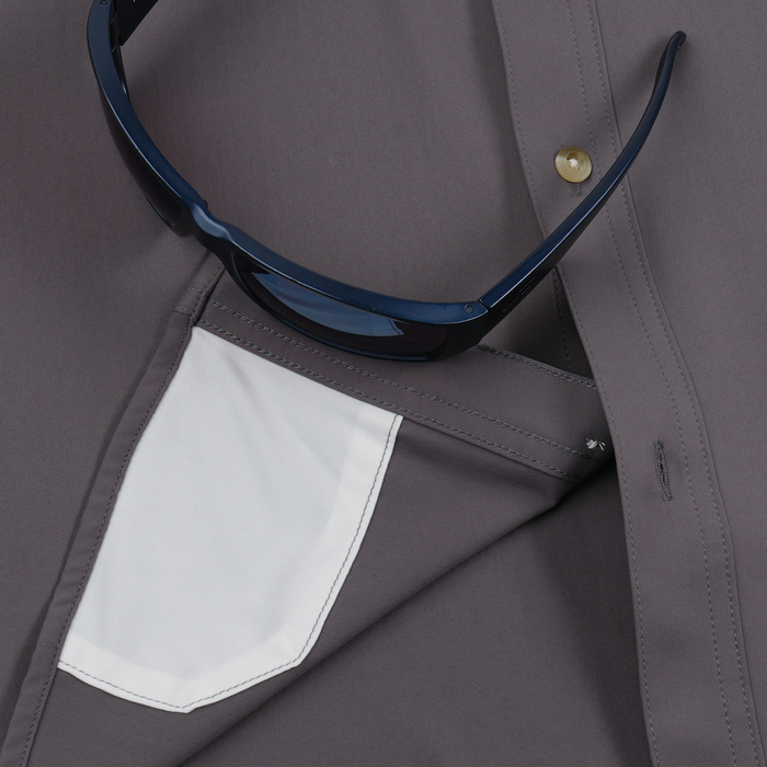 Close-up of The Tripletail shirt pocket with sunglasses tucked inside, showcasing fabric detail.