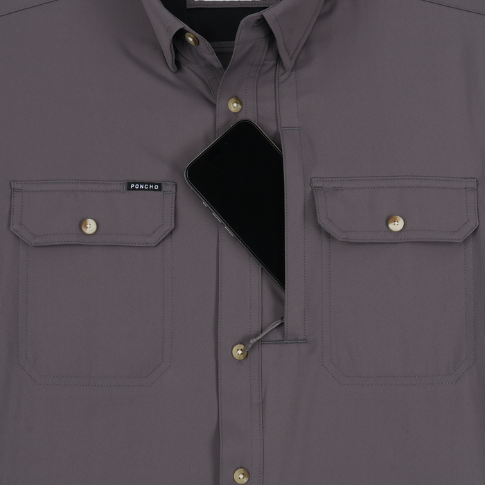 Close-up of The Tripletail shirt showing two front buttoned pockets and a smartphone partially tucked inside the left pocket.