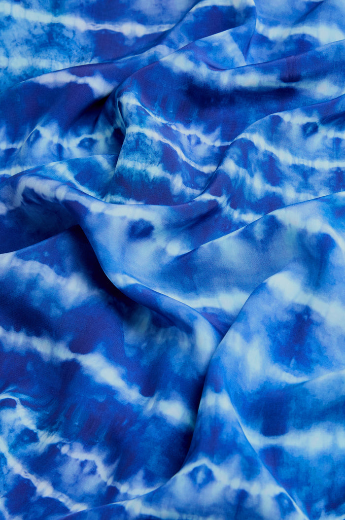 The Tie Dye Printed Viscose Shirt features blue and white wavy patterns on soft, draped fabric—ideal for a unique, lightweight indigo shirt.