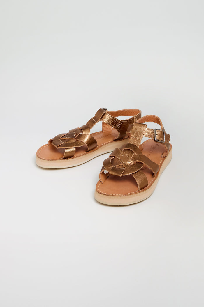 A pair of Tulum Leather Sandals featuring a handcrafted flower-shaped design on the toe and ankle straps with side buckles, displayed against a plain white background.